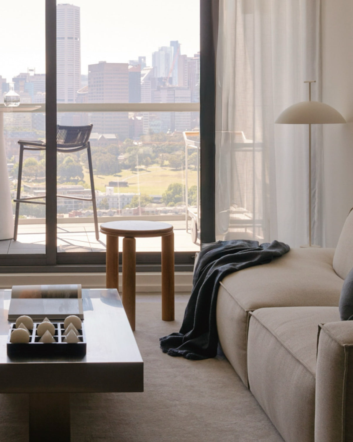 Small oak side table, stainless steel coffee table and beige couch