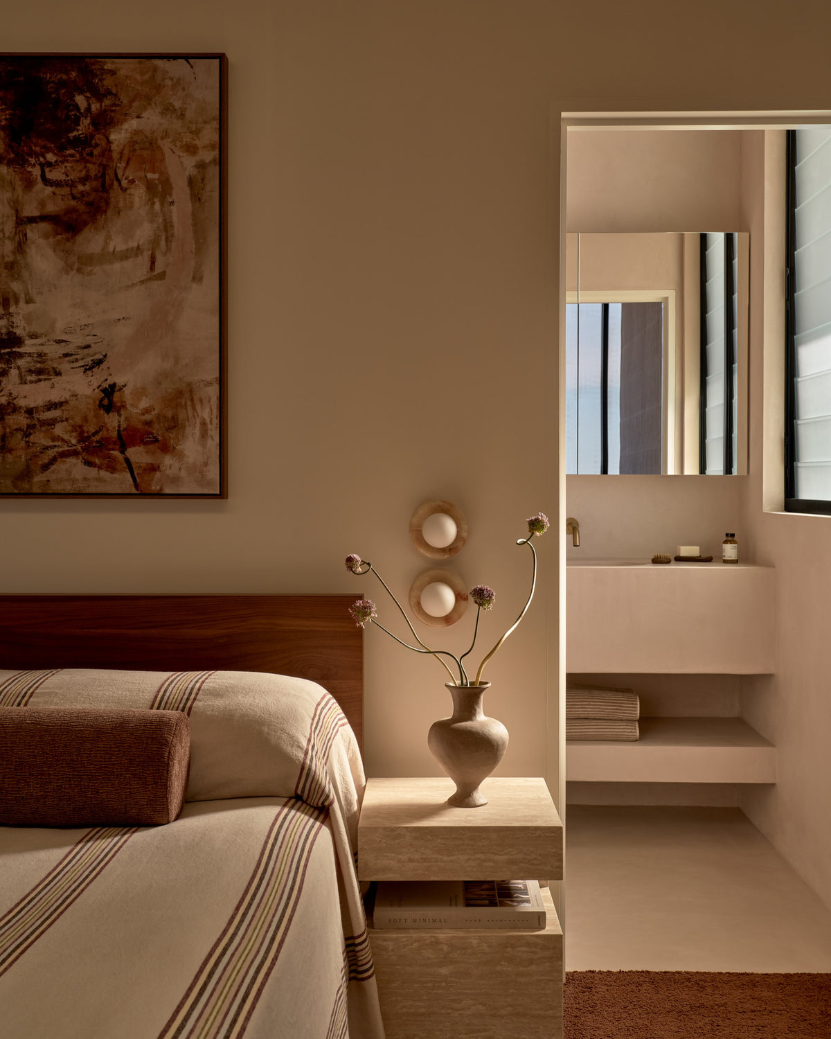 Cream travertine side table styled in a bedroom