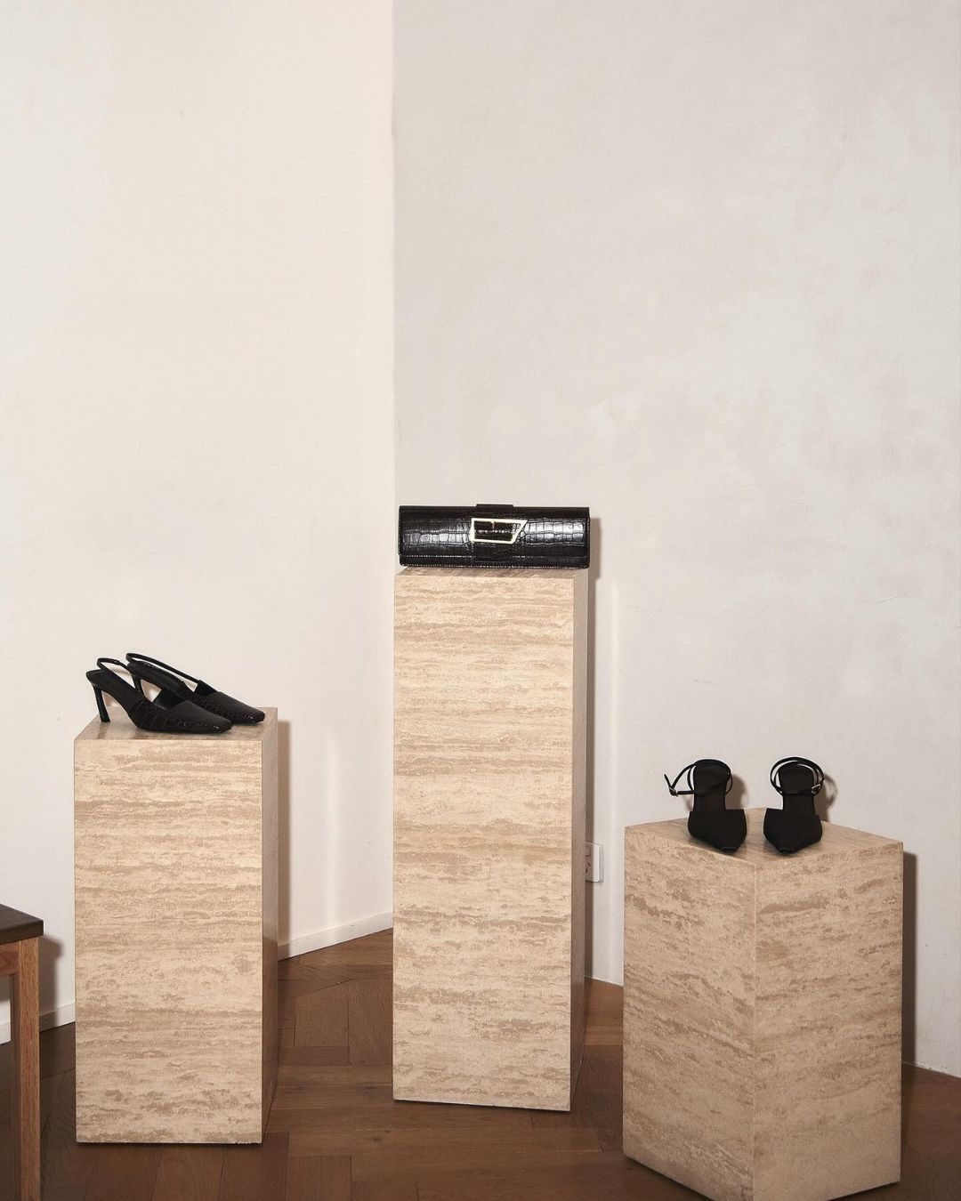 Three cream travertine plinths at different heights