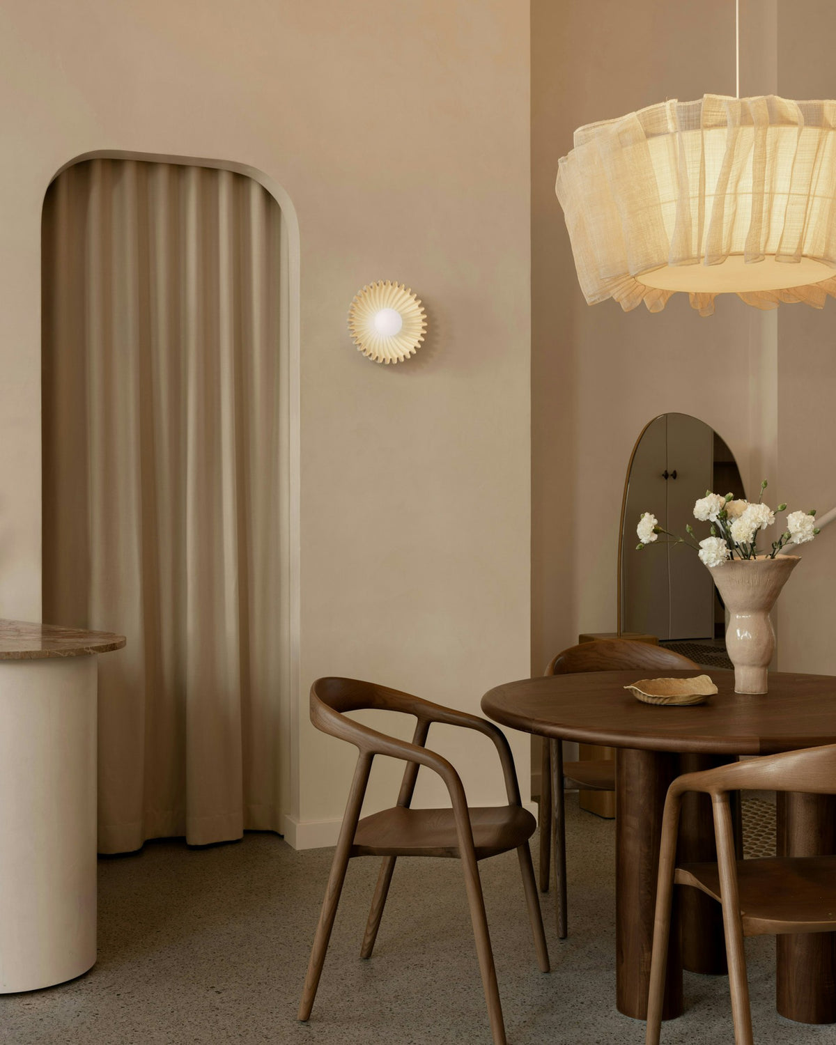 Round walnut dining table styled in a boutique