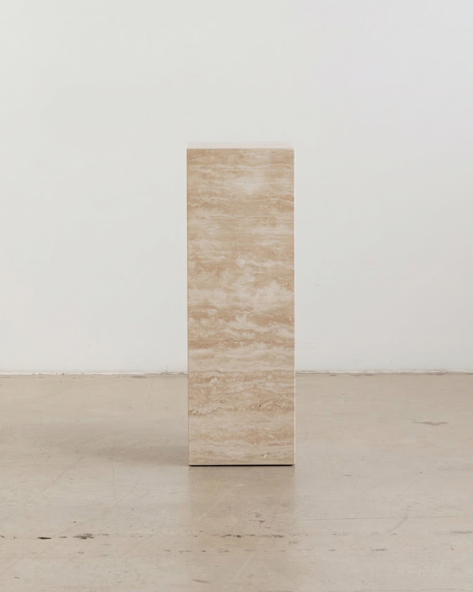 Tall cream travertine plinths