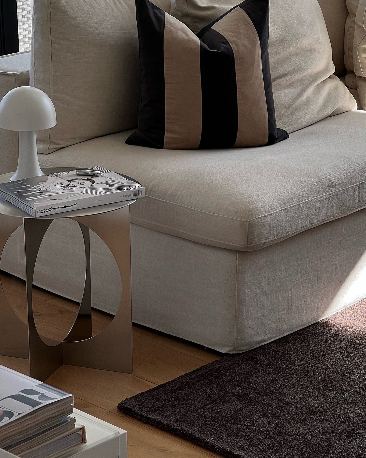 Stainless steel side table styled next to a couch