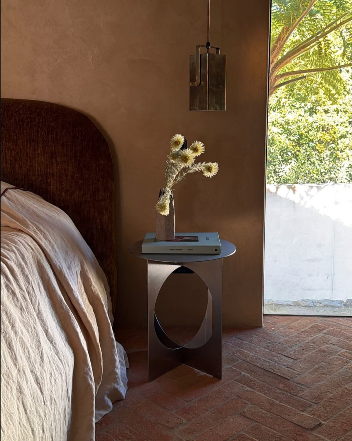 Stainless steel bedside table next to a bed