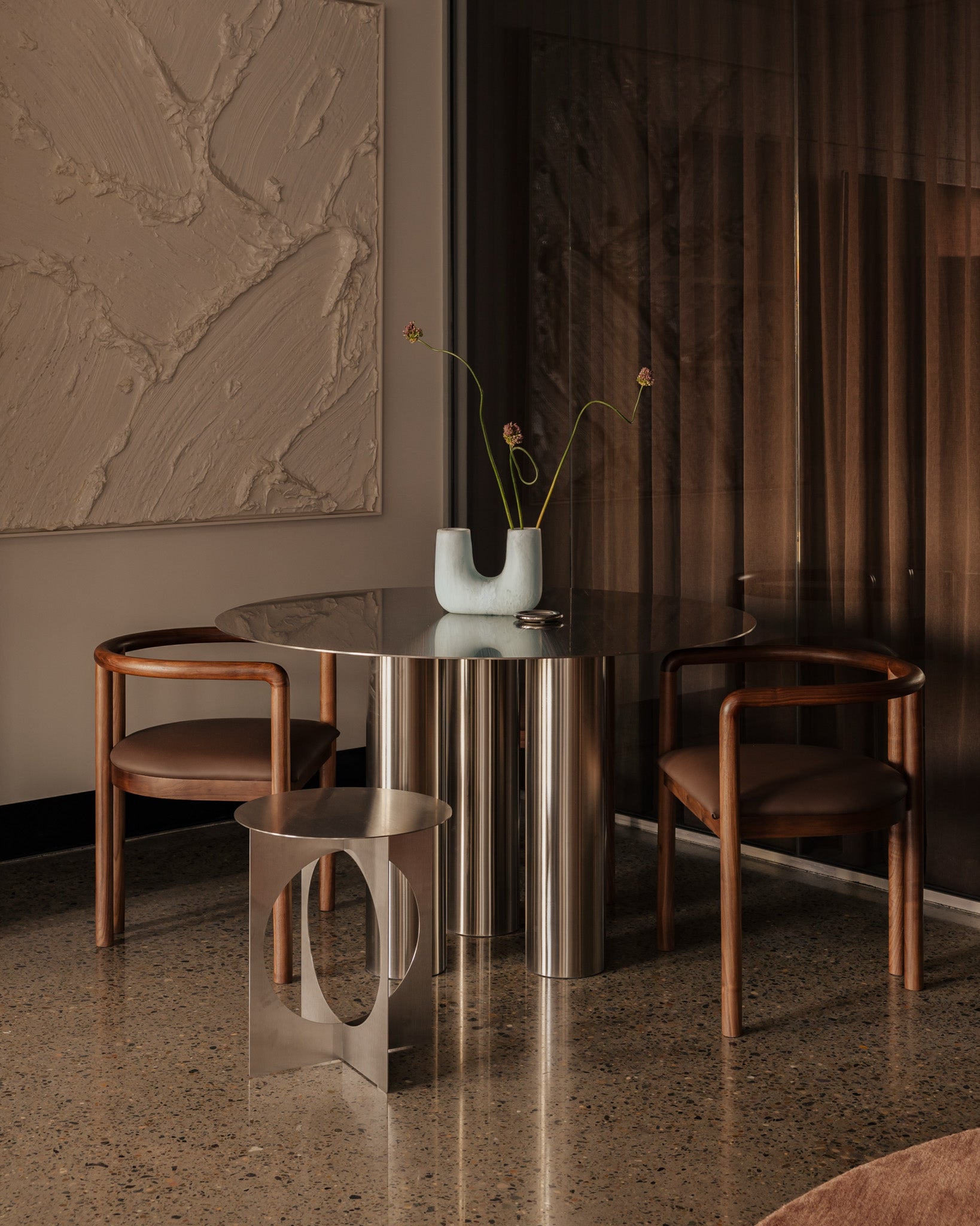 Modern dining room featuring a stainless steel dining table
