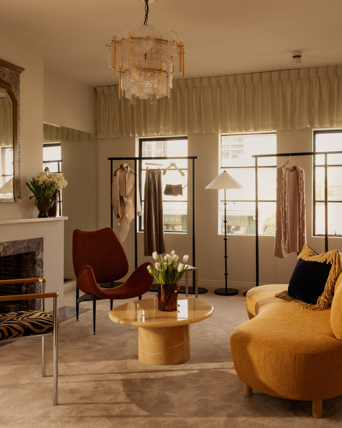 A styled interior room with a yellow curved sofa and onyx coffee table.