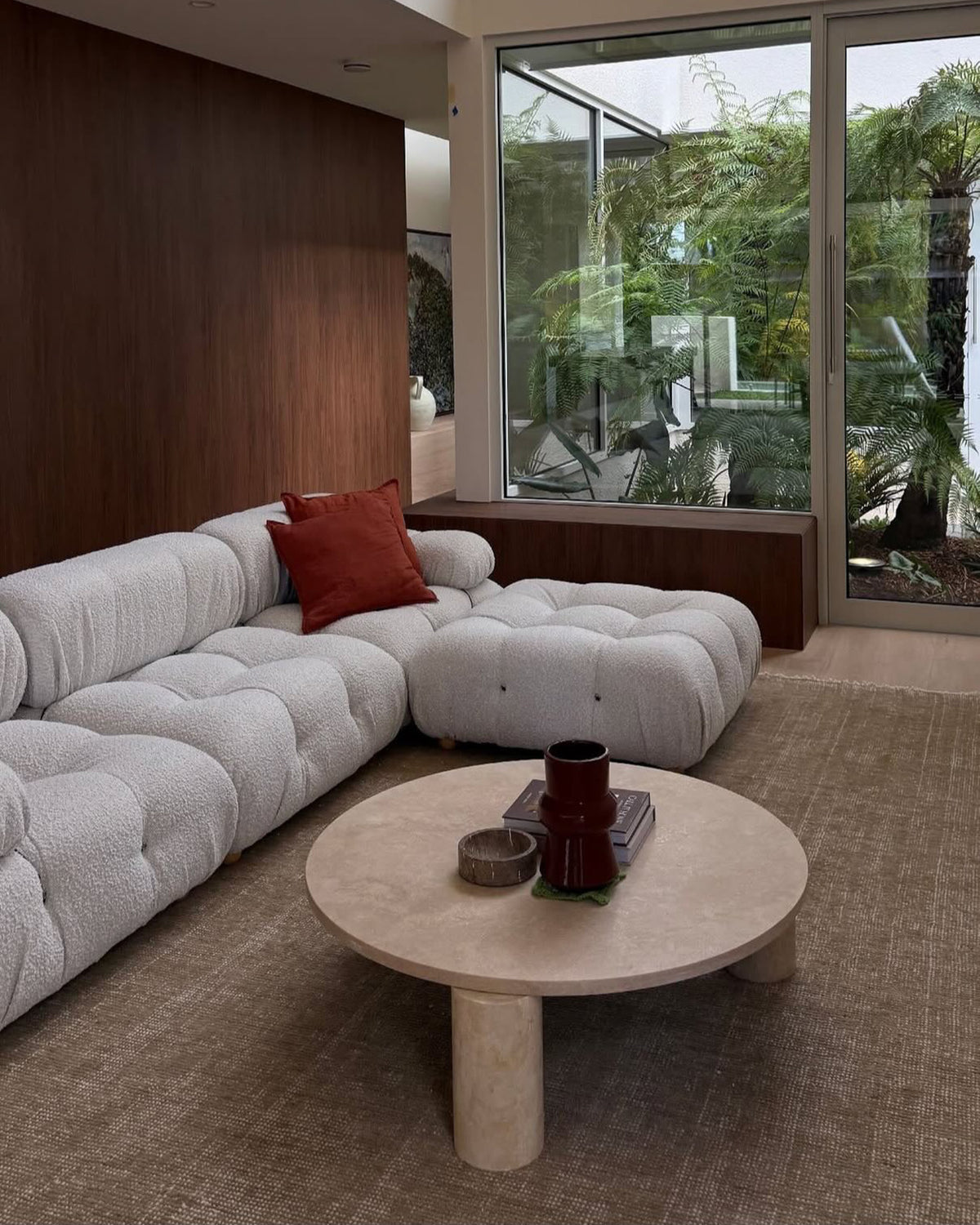 Round cream travertine coffee table styled in a living room