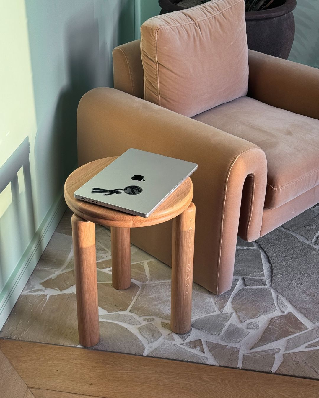 Small oak side table styled next to a lounge chair