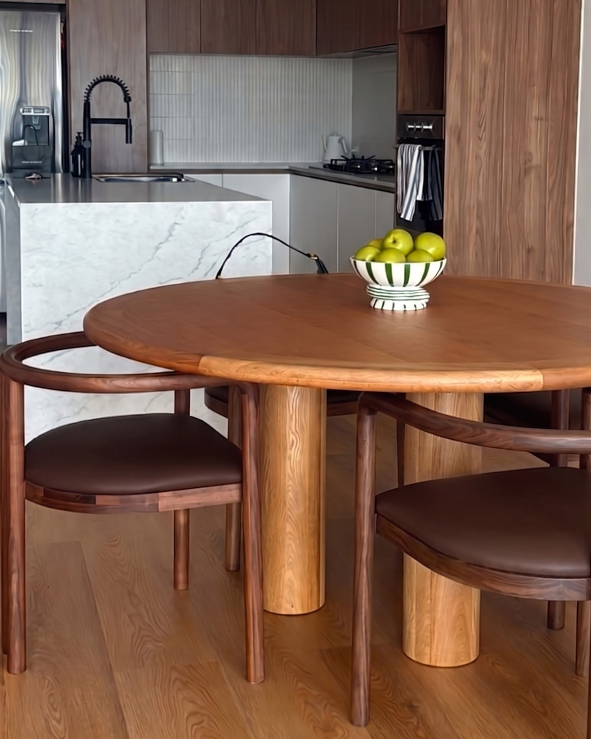 Round oak dining table styled in a dining room