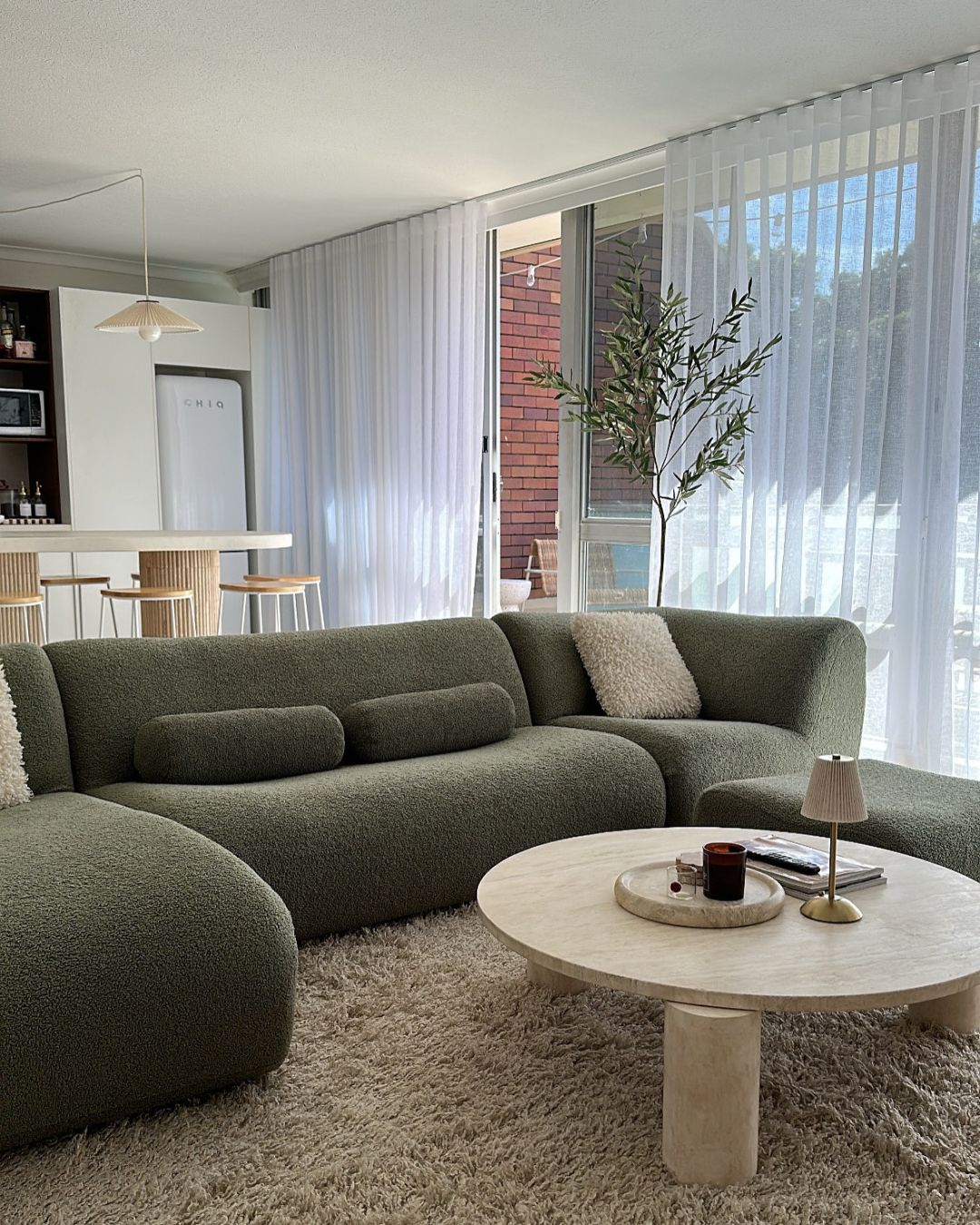 Round cream travertine coffee table styled in a living room
