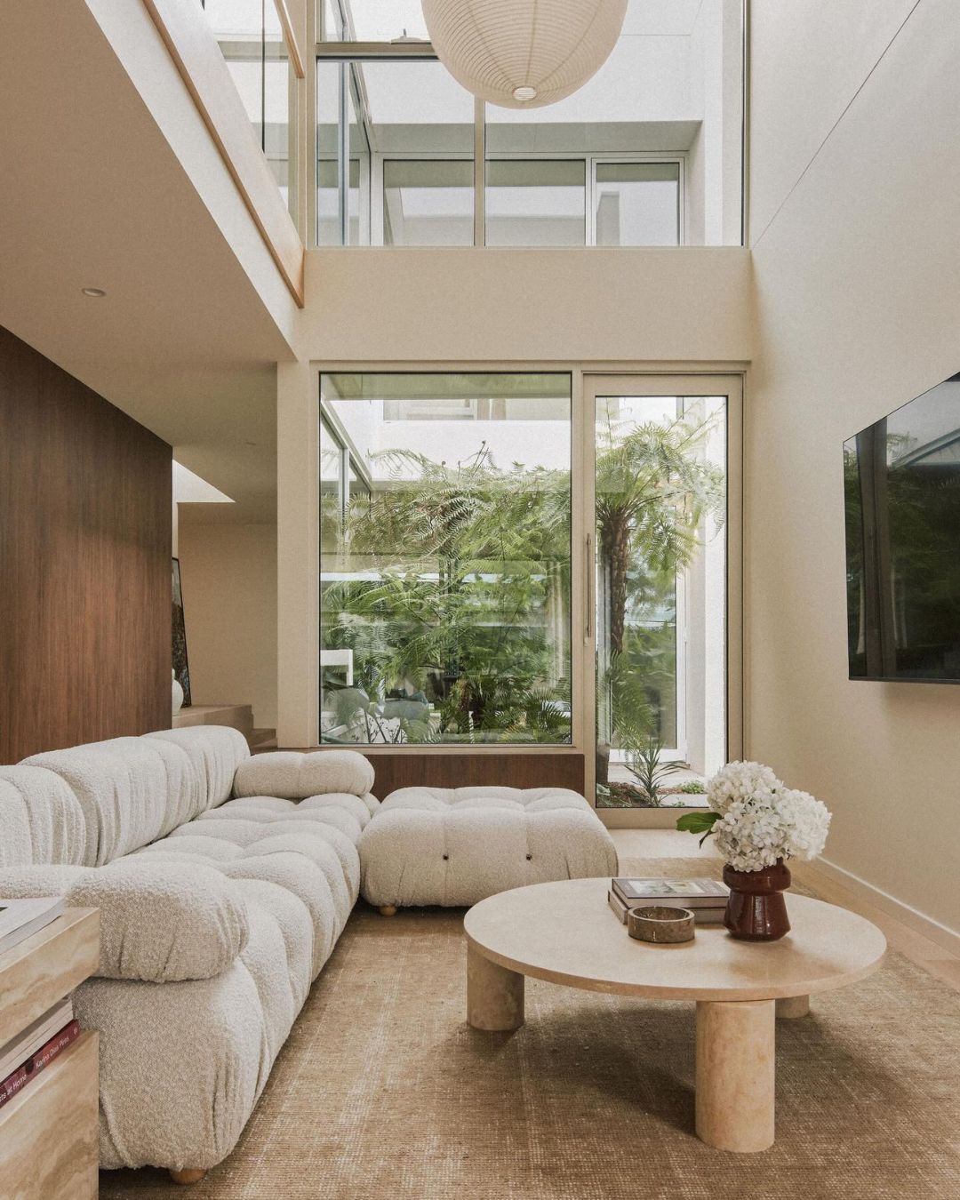 Round cream travertine coffee table styled in a living room