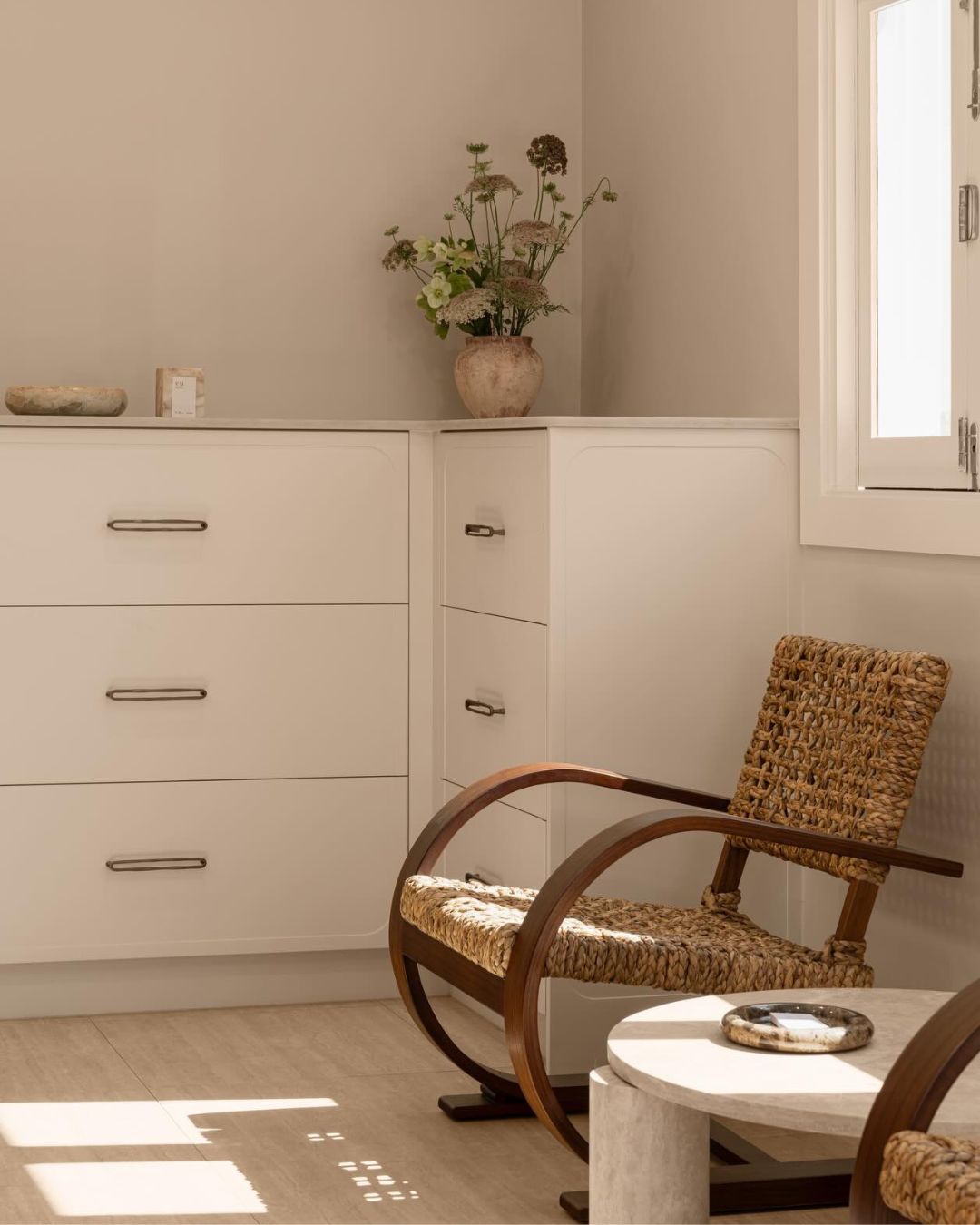 Round cream travertine coffee table styled in a bedroom