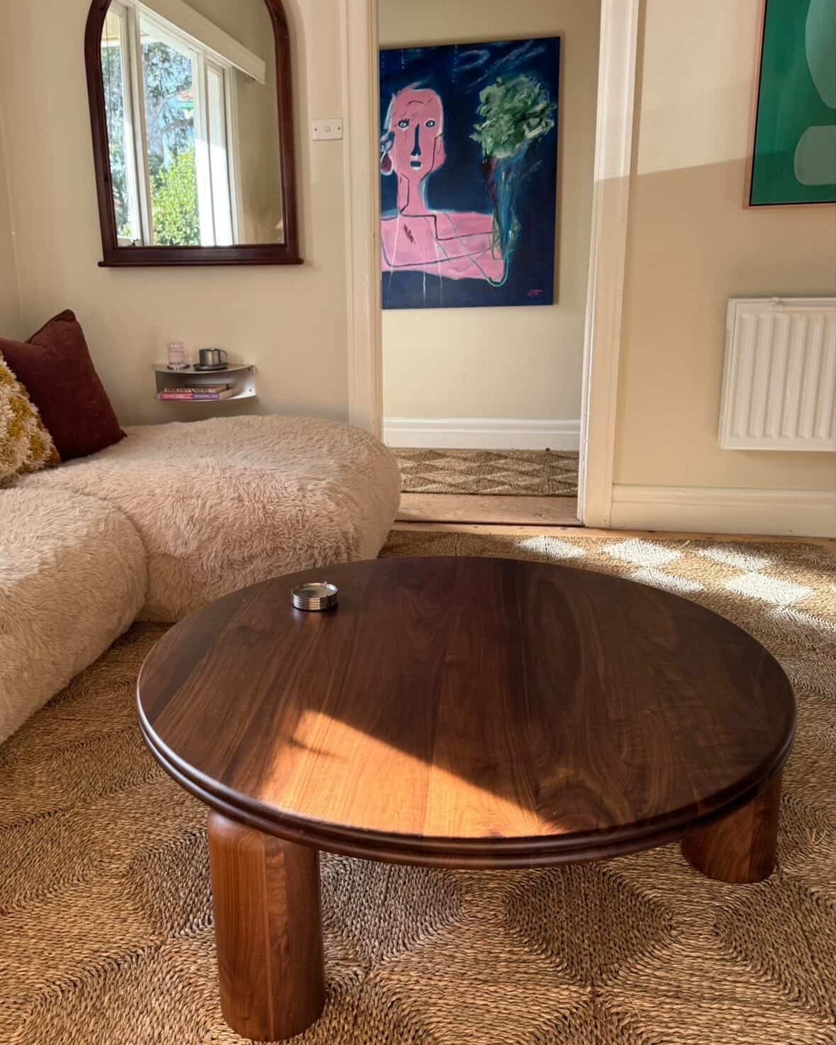 Round walnut timber coffee table in a living room