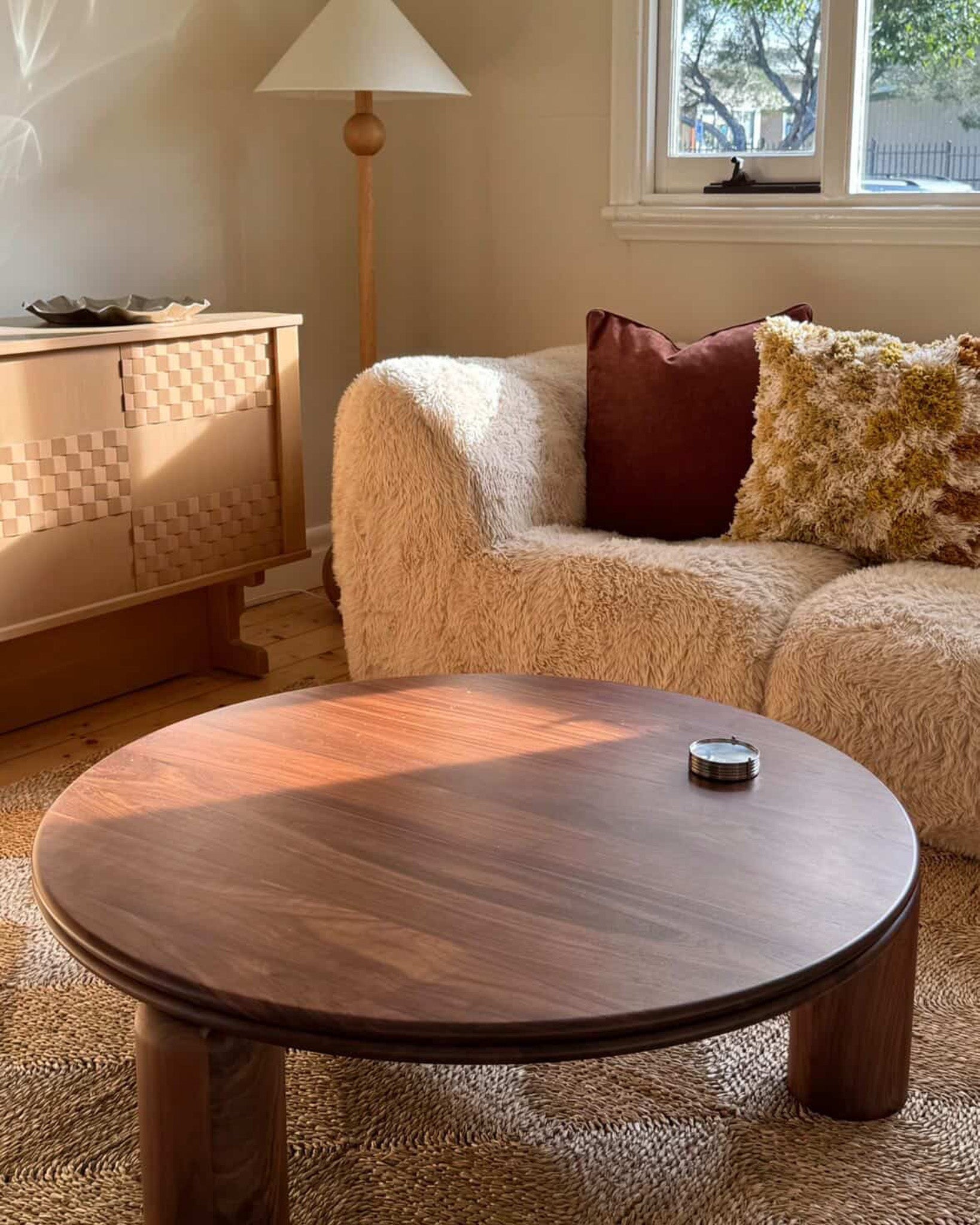 Round walnut timber coffee table in a living room