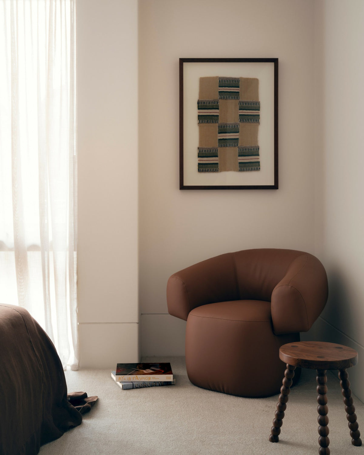Small walnut stool styled in a bedroom