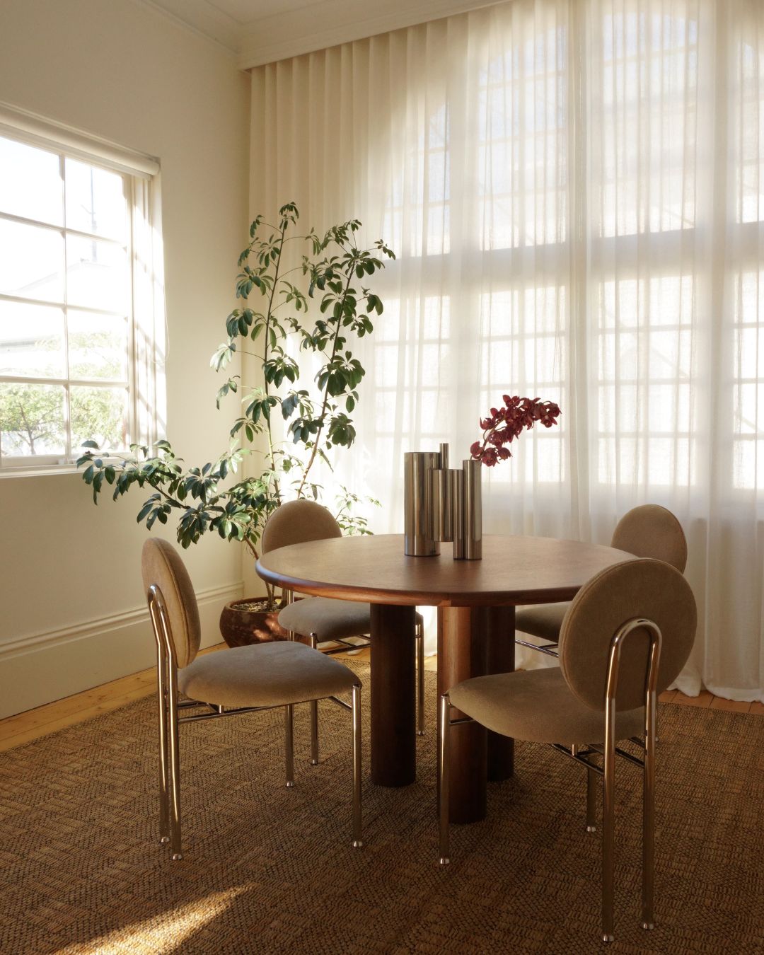 Round walnut dining table styled in a dining room
