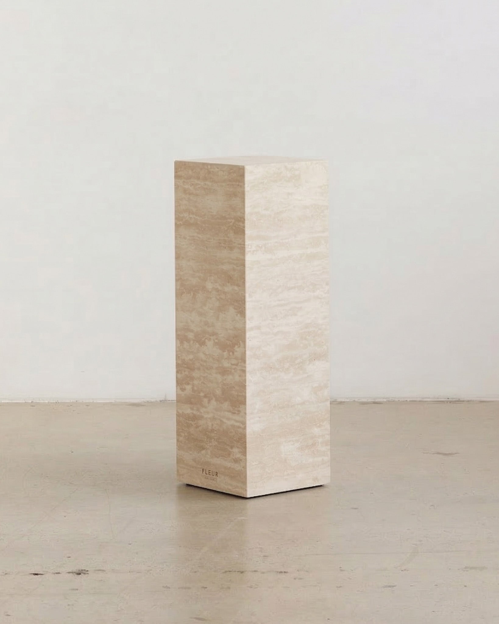 Tall cream travertine plinths