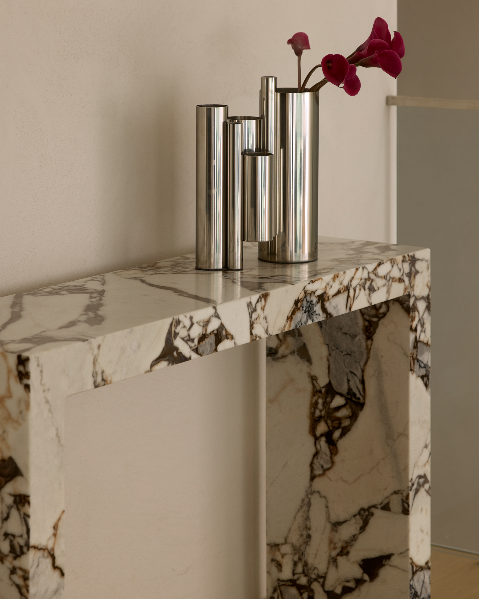 Stainless steel vase paced on a console table.