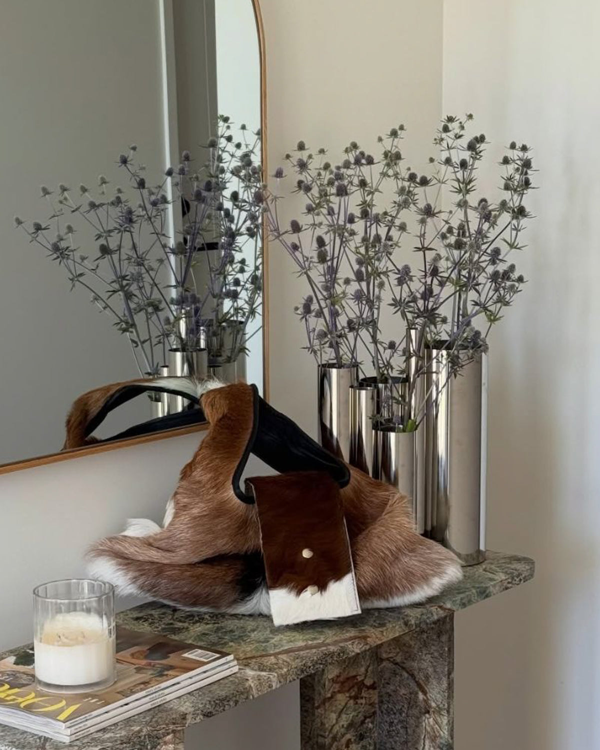 Stainless steel vase styled on a console table