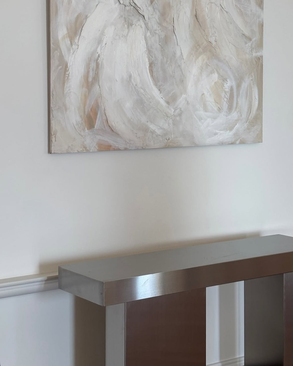 Stainless steel console table below art
