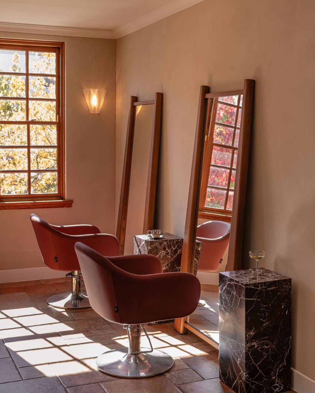 A salon styled with marble plinth side tables