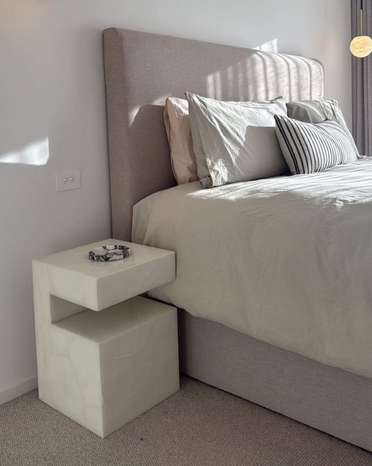 A white onyx marble bedside table