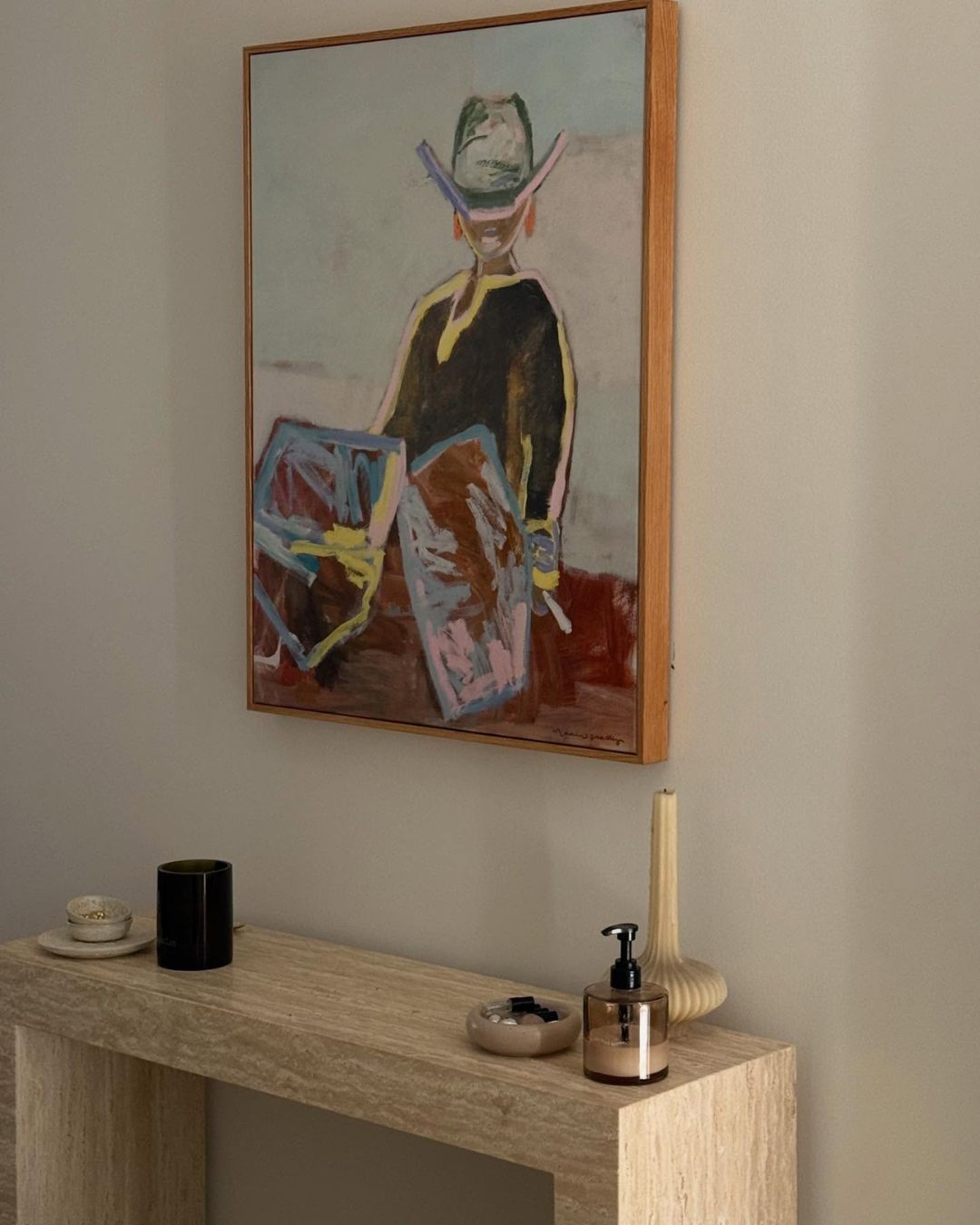 Cream travertine console table styled below art