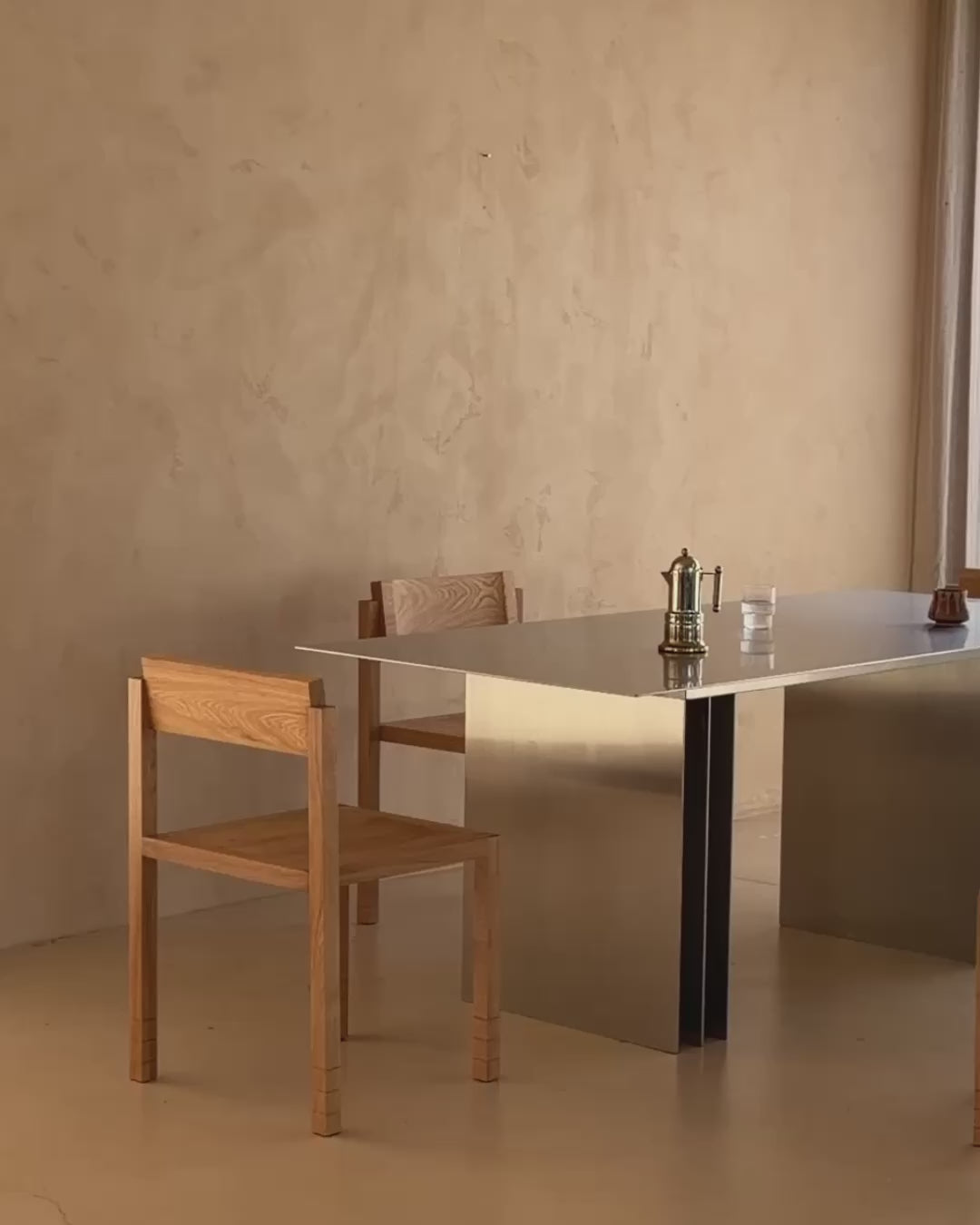 Stainless steel dining table styled with timber chairs